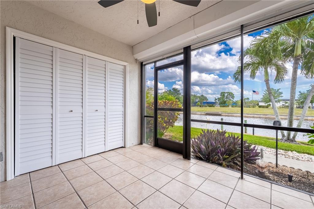 Screened patio with large format tile flooring, louvered bi-fold doors, and a ceiling fan