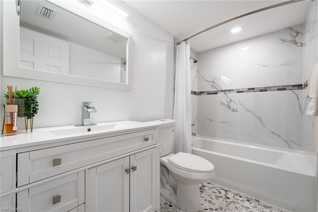 Vanity with integrated sink, contemporary chrome faucet, and framed mirror