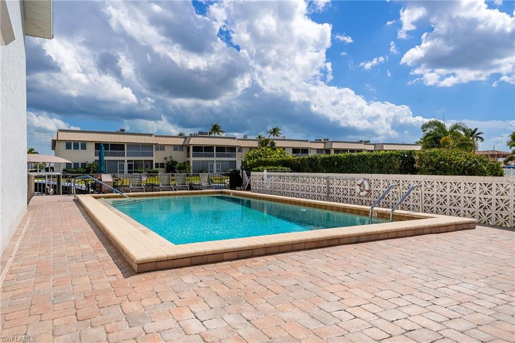Outdoor swimming pool, paver patio, decorative privacy wall, mature landscaping