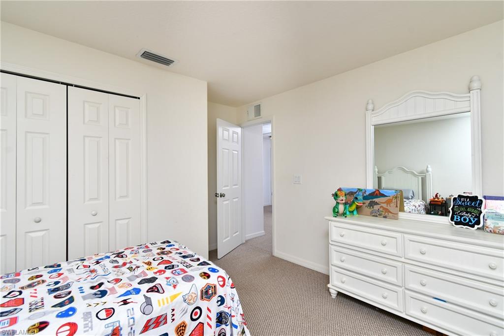 Recessed lighting, light neutral wall color, carpeted flooring, and a white paneled bi-fold closet