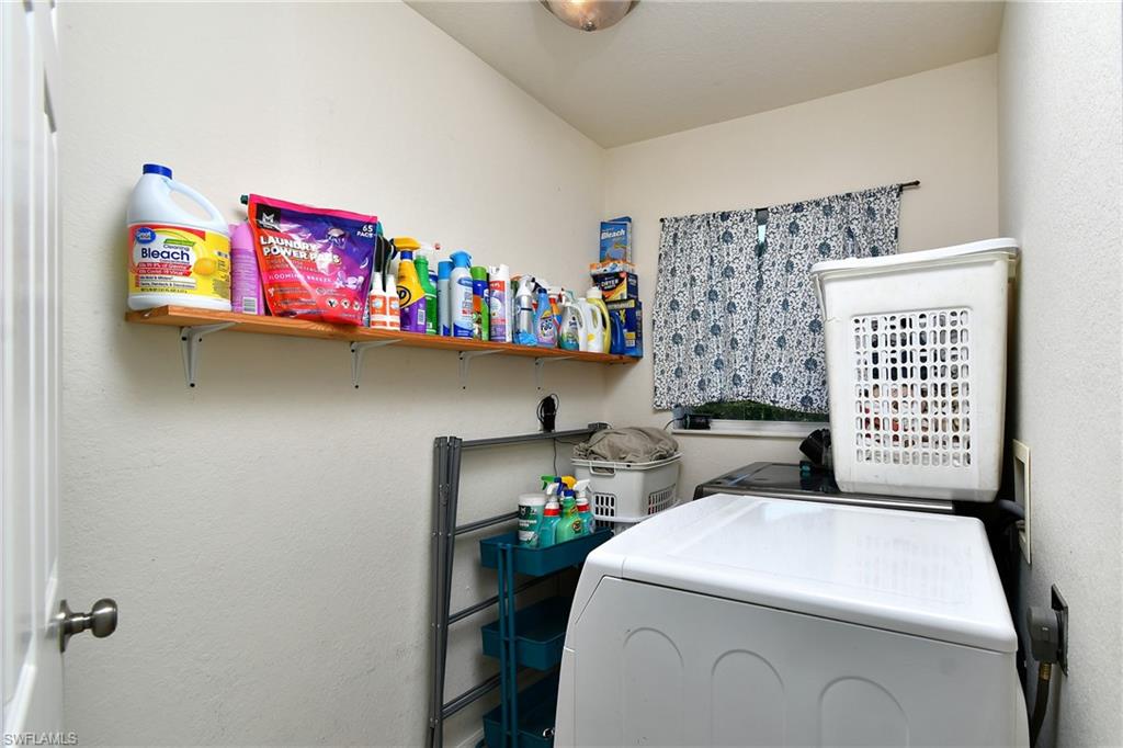 Laundry area with open shelving and a window