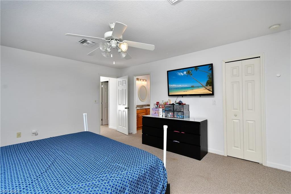 Wall-to-wall carpeting and a ceiling fan with integrated lighting