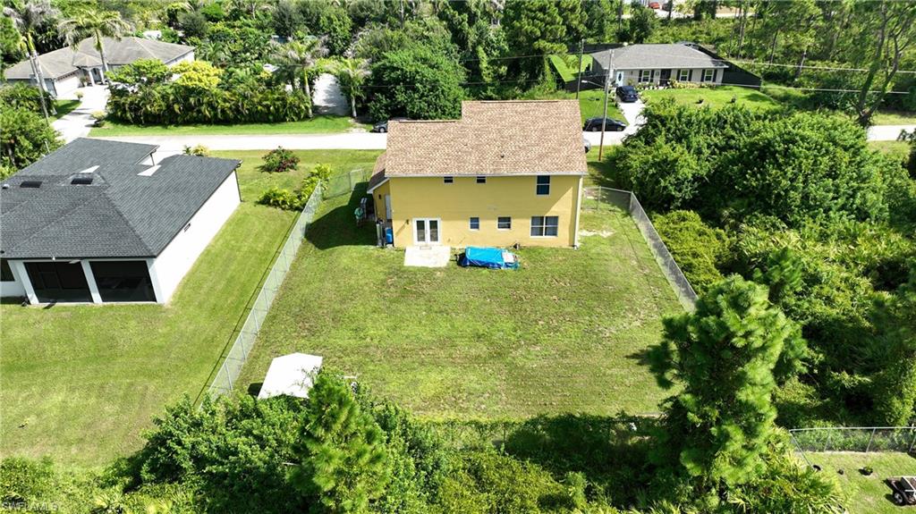Two-story residence featuring a shingle roof and a fenced perimeter