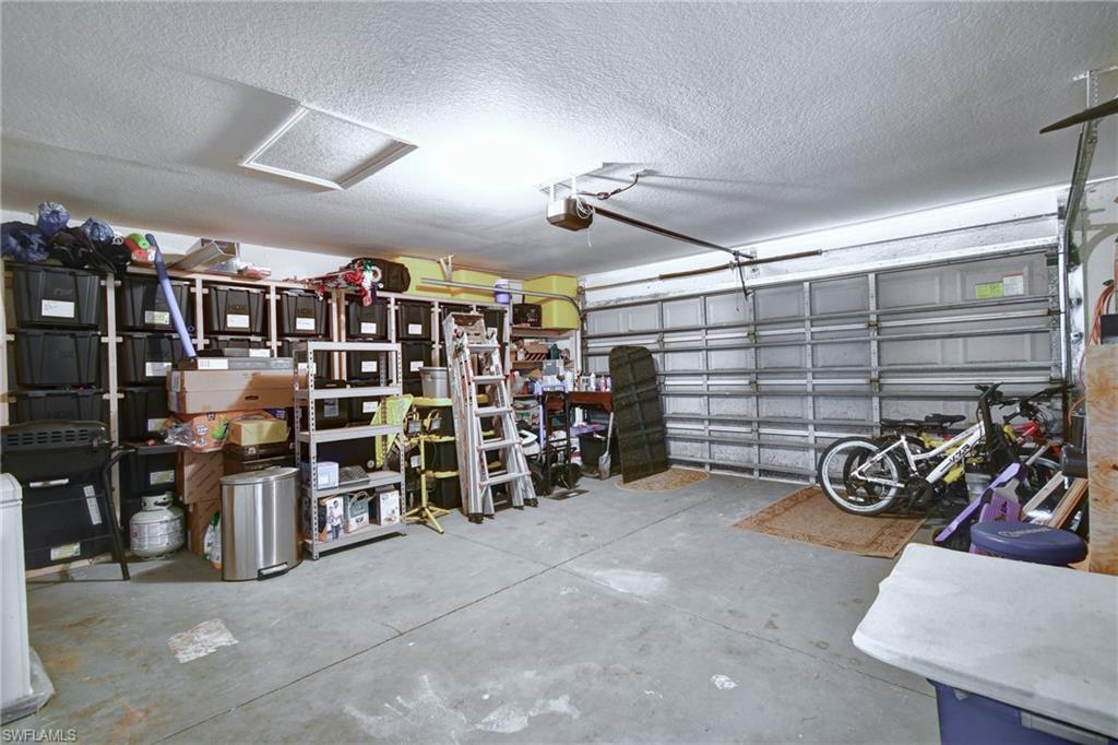 Concrete flooring with a white textured ceiling and recessed lighting