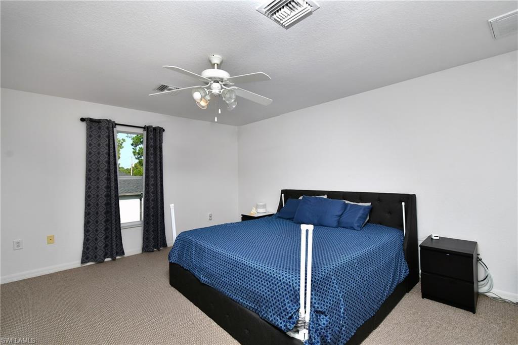 Spacious room featuring neutral carpet, a single window, and an overhead ceiling fan with lighting