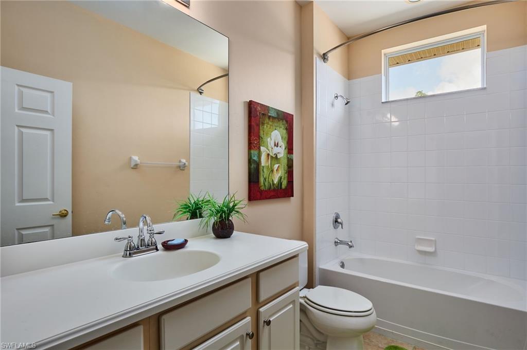 Integrated vanity with an oval sink, chrome faucet, and expansive mirror