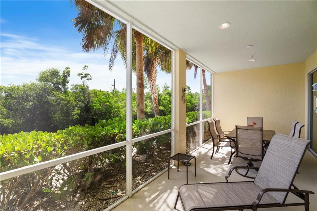Screened outdoor area with recessed lighting, offering abundant natural light and tropical foliage