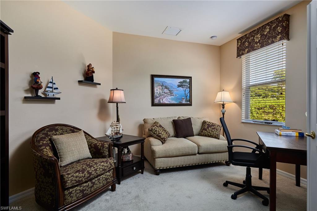Carpeted interior with neutral wall tones and a single window featuring blinds and a decorative valance