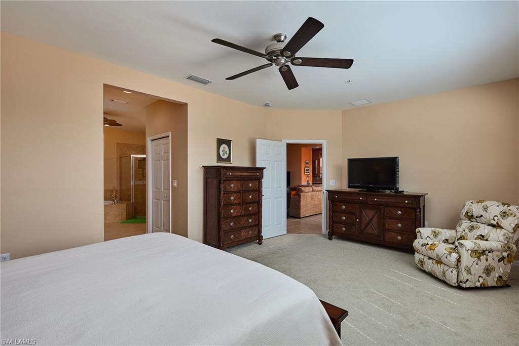 Recessed lighting, ceiling fan, neutral wall paint, carpeted flooring, and a built-in tub