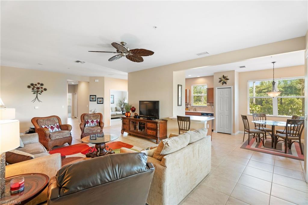 Spacious main living area featuring tile flooring, ceiling fan, and large windows