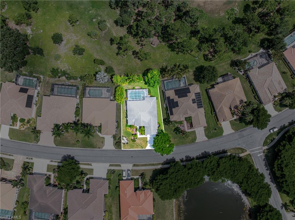 Aerial perspective of a property featuring a screened-in swimming pool and mature landscaping