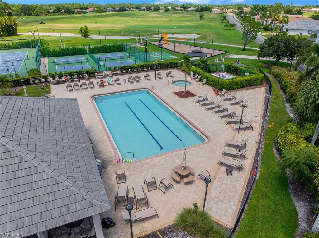 Expansive outdoor swimming pool with integrated spa and surrounding paver patio