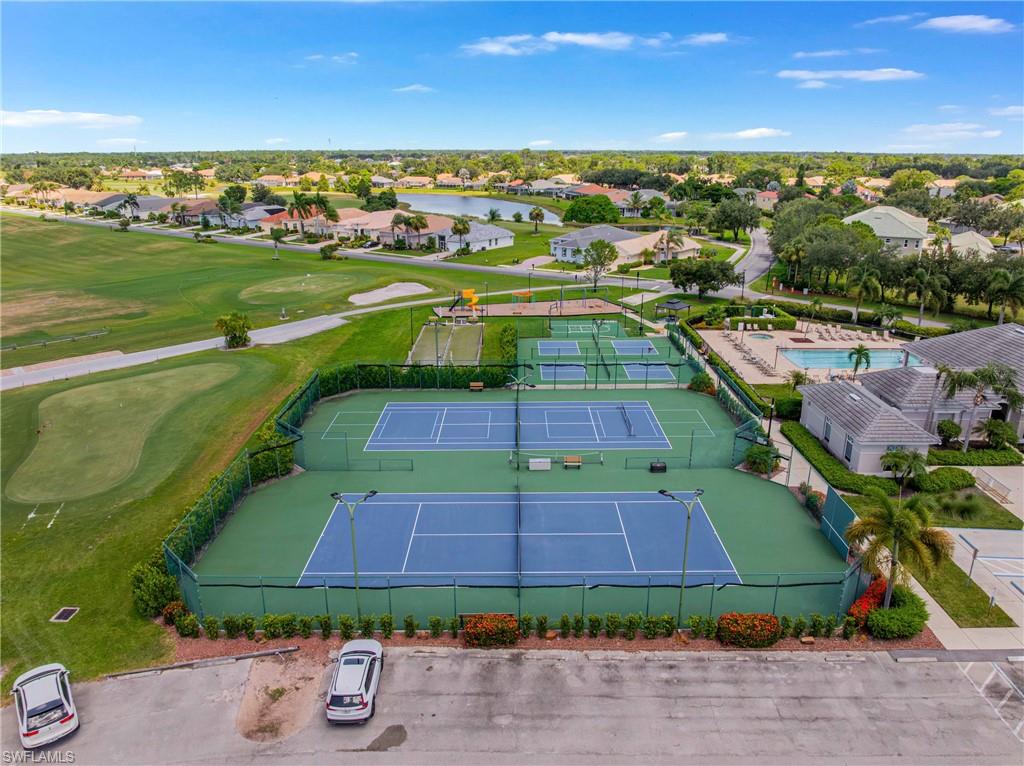 Multiple tennis courts, golf course access, and a swimming pool with a surrounding patio