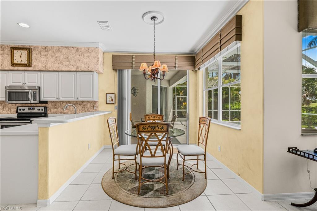 Recessed lighting, tile flooring, built-in kitchen cabinetry, stainless steel appliances, and a chandelier lighting fixture