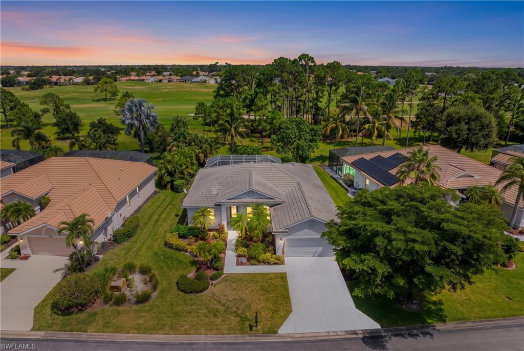 Contemporary single-story residence featuring a screened-in pool enclosure, an attached two-car garage, and a lush landscaped front yard