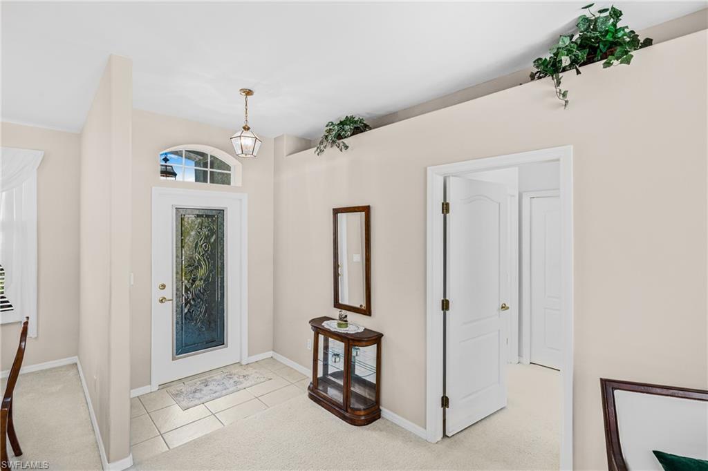 Entryway featuring a decorative glass door, arched transom window, and a bronze pendant light fixture