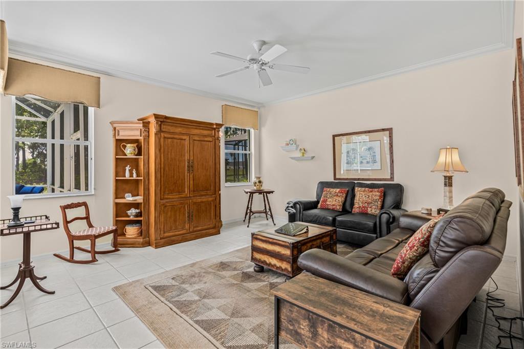 White tile flooring, multiple windows, ceiling fan, crown molding, and light-toned wall paint