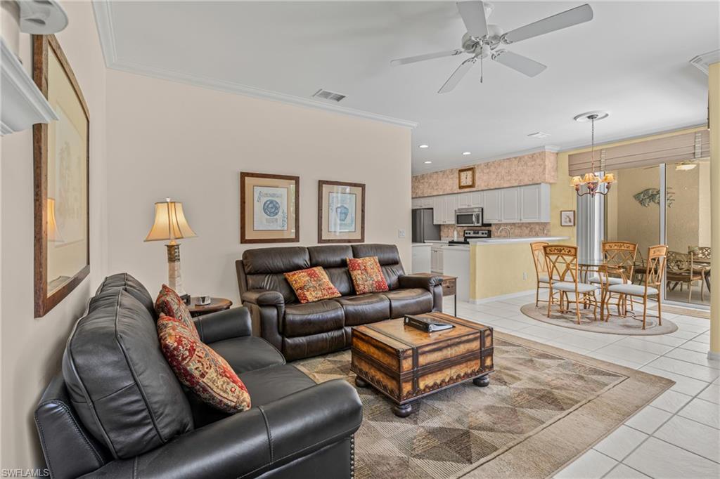 Living area featuring tile flooring, crown molding, and a ceiling fan