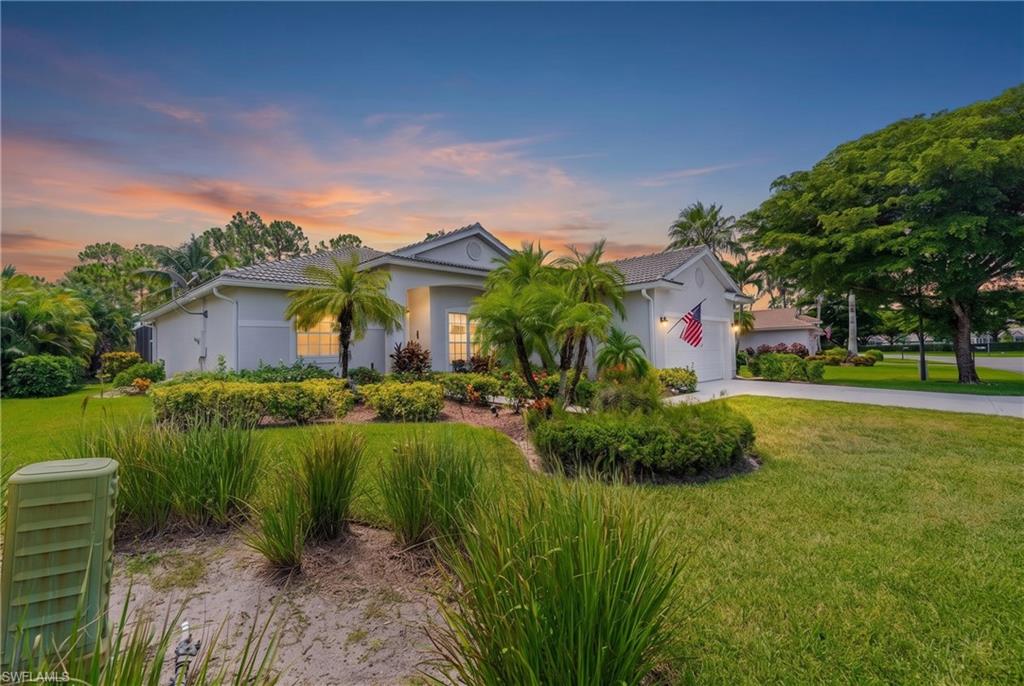 Single-story residence with a tiled roof, attached garage, and mature landscaping