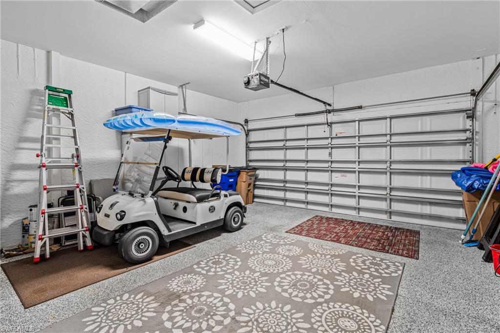 Garage featuring a finished floor, overhead lighting, and an automatic garage door opener