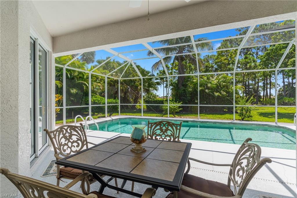 Screened patio with a private swimming pool, surrounded by lush green landscaping