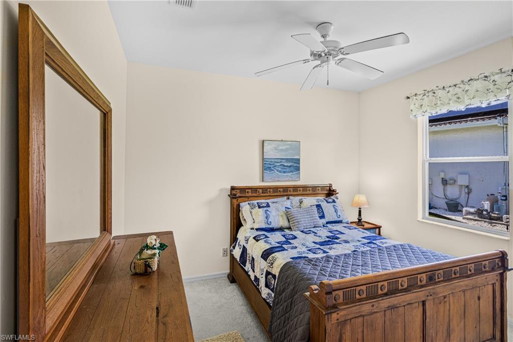 Bright room featuring a multi-pane window, ceiling fan with integrated lighting, and neutral wall paint
