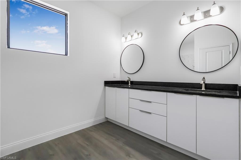 Full bath featuring dark wood finished floors and double vanity