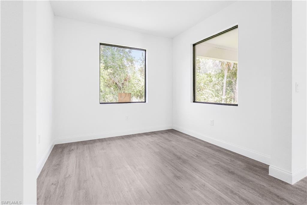 Empty room with light wood-type flooring and plenty of natural light