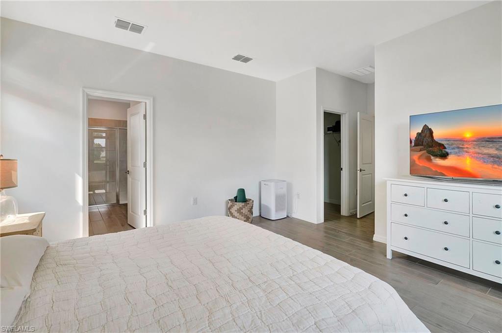 Bedroom featuring dark wood-type flooring and ensuite bath