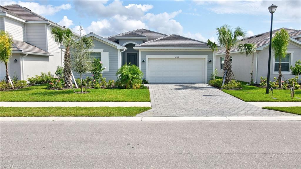 View of front of house with a garage and a front yard