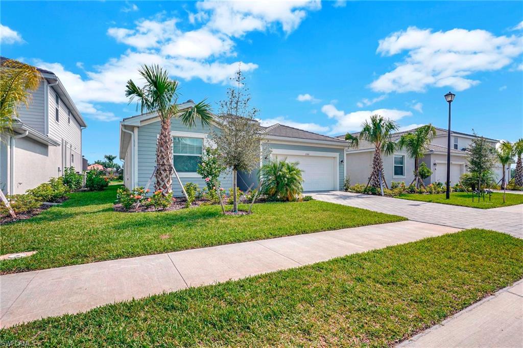 Ranch-style home featuring a garage and a front lawn