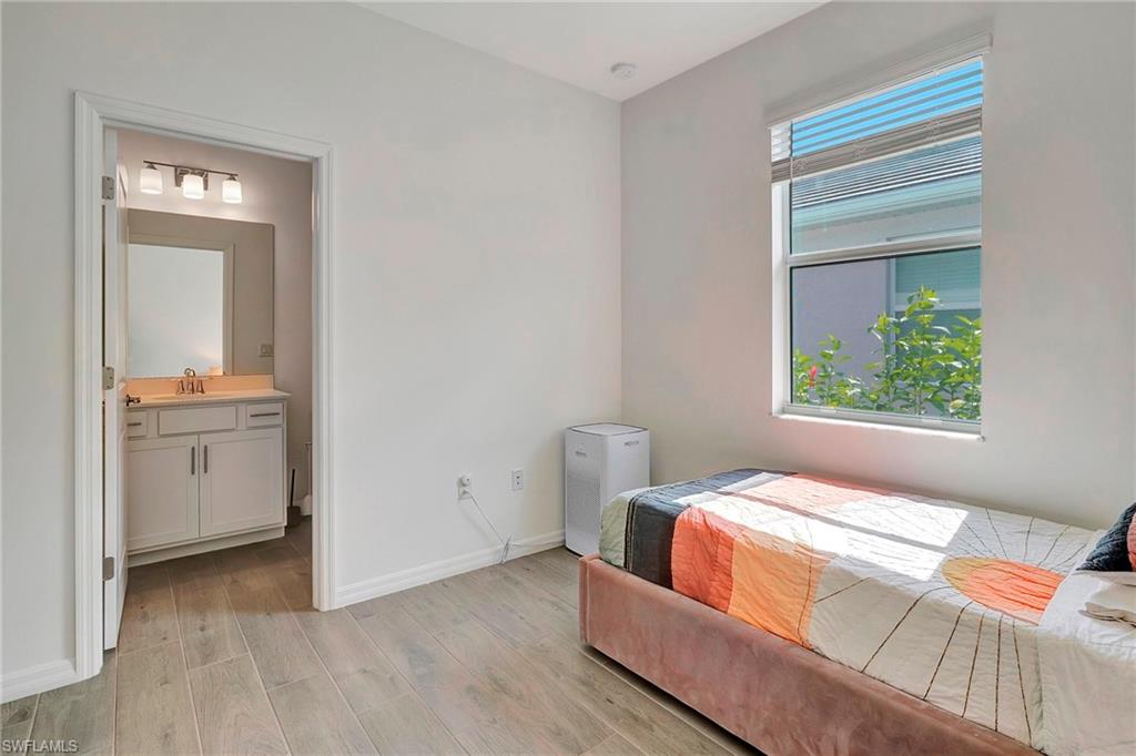 Bedroom featuring sink, connected bathroom, and light hardwood / wood-style flooring