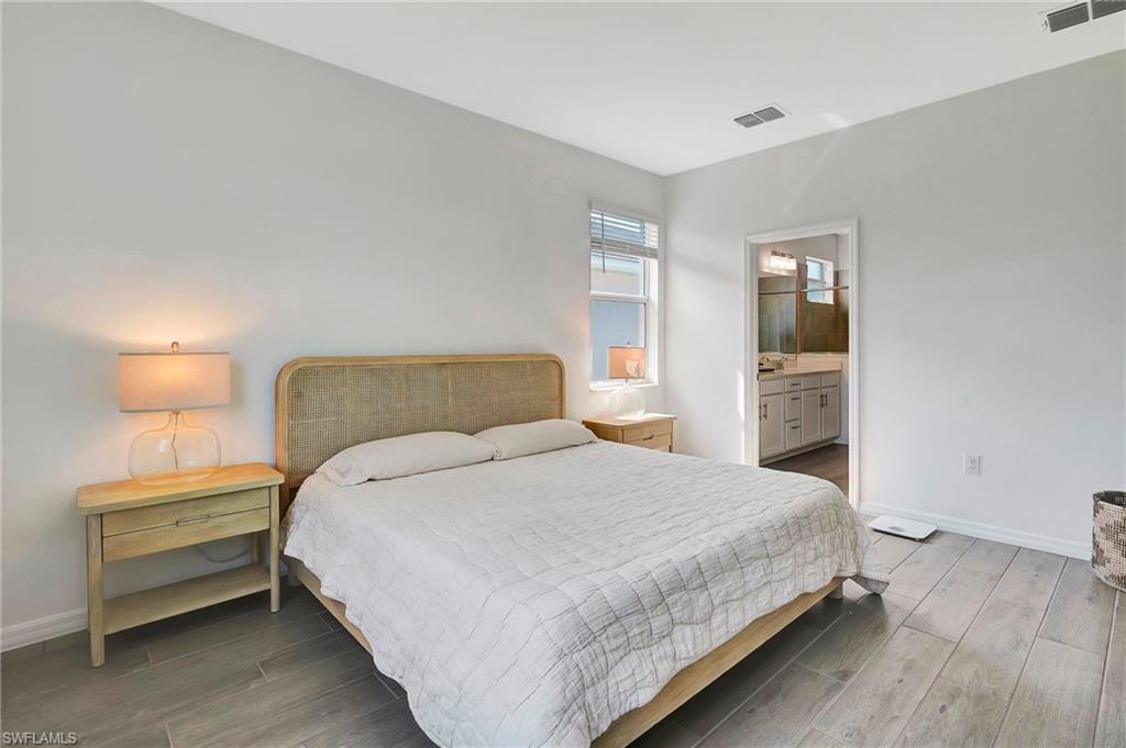 Bedroom featuring ensuite bath and wood-type flooring