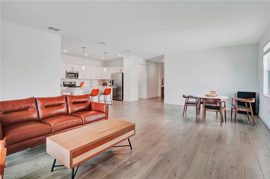 Living room with light hardwood / wood-style floors and sink