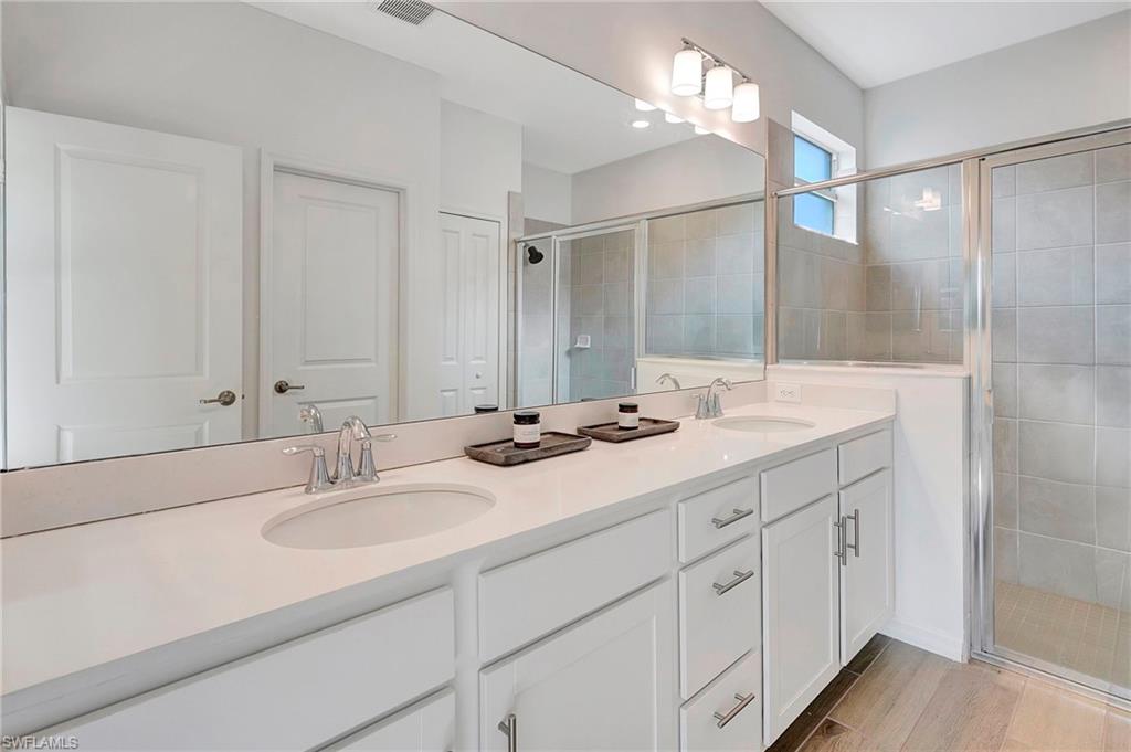 Bathroom with a shower with door and dual bowl vanity