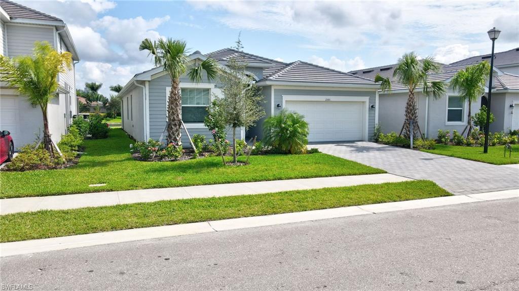 Ranch-style home featuring a garage and a front lawn