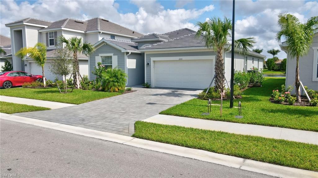 View of front of property with a front yard and a garage