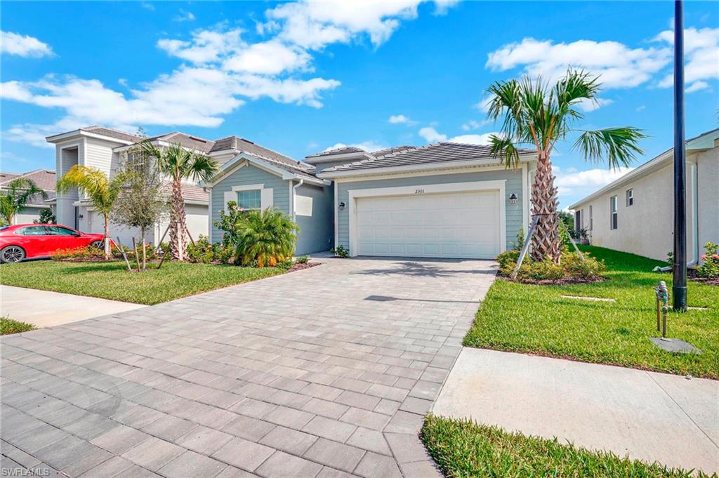 View of front of house with a front yard and a garage