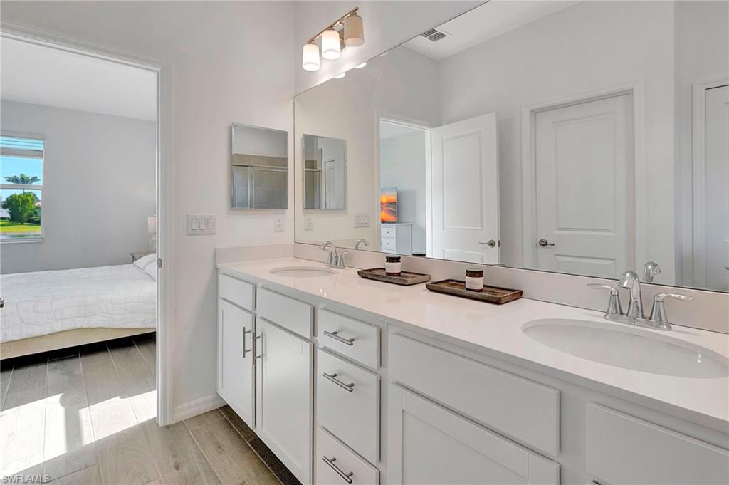 Bathroom with double vanity and wood-type flooring