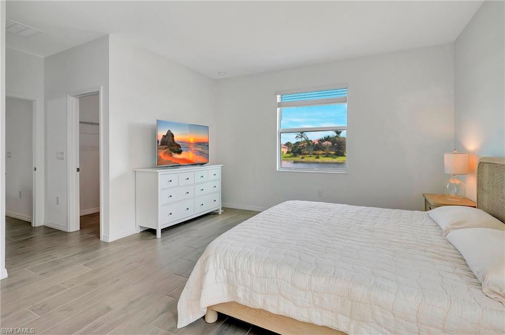 Bedroom featuring a spacious closet, a closet, and light hardwood / wood-style floors