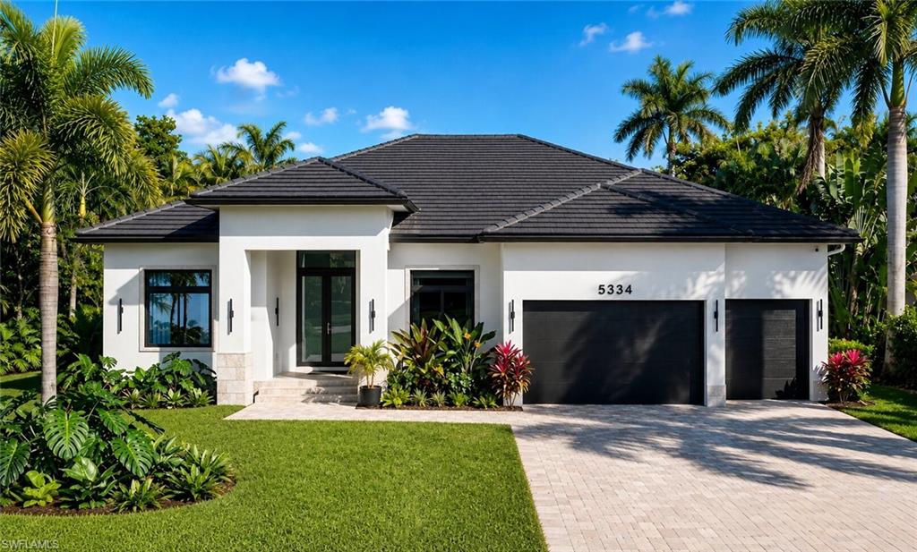 Modern exterior featuring a dark tile roof, white stucco facade, and black framed windows