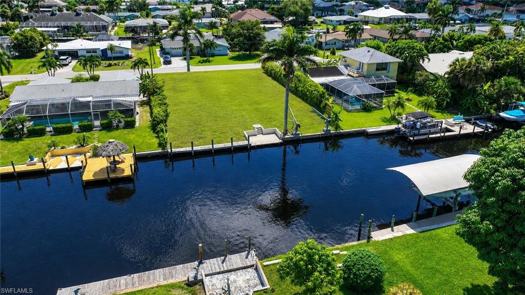 Waterfront property with canal access, featuring a private dock and a covered boat lift