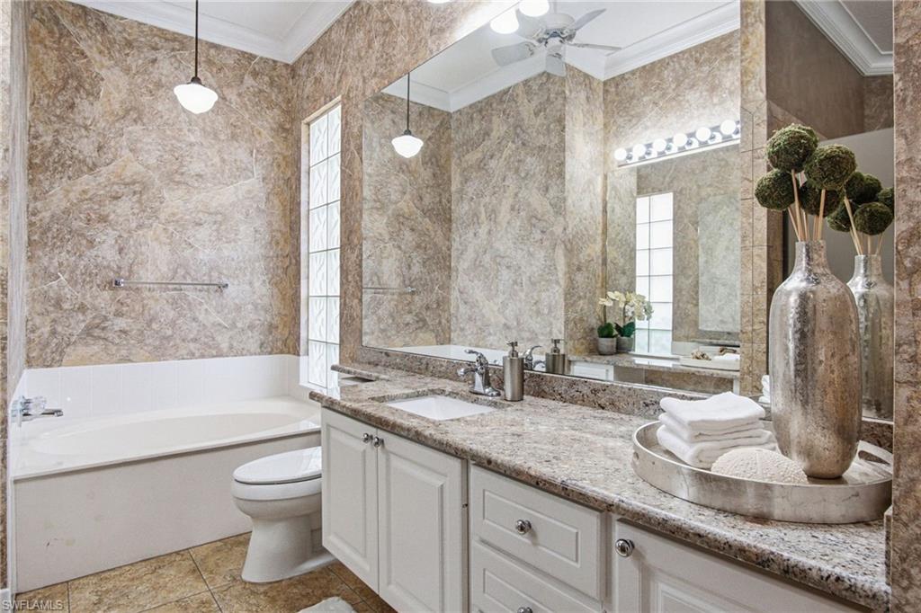 Primary bath has 2 separate sinks and toilets with a frameless glass, enclosed shower, and soaking tub