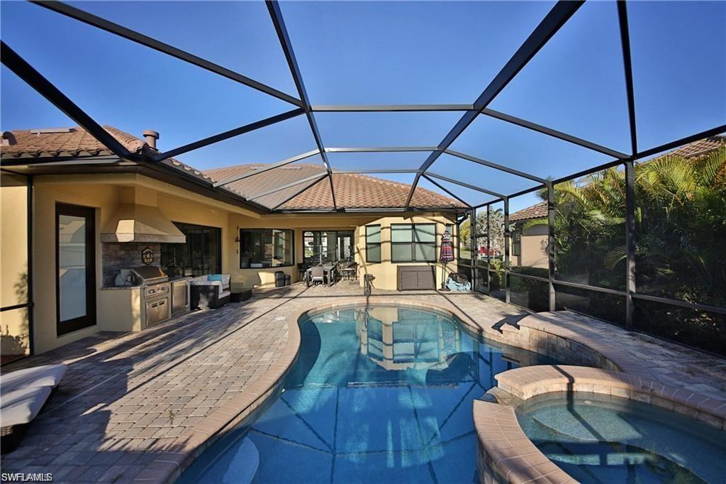 View of swimming pool with a patio area, area for grilling, a lanai, an in ground hot tub, and a grill