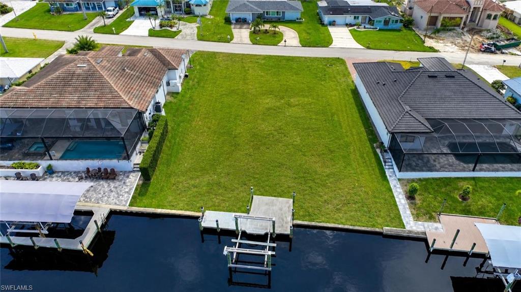 Renderd photo Expansive green lot featuring a private dock and direct water access