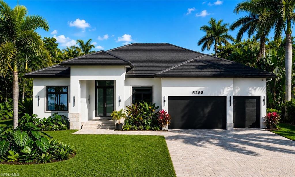 Modern exterior featuring a dark tile roof, white stucco facade, and black framed windows