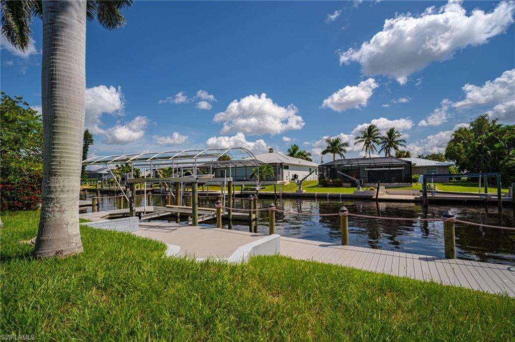 Waterfront property featuring a private boat dock with a covered lift, a dedicated boat slip, and direct canal access