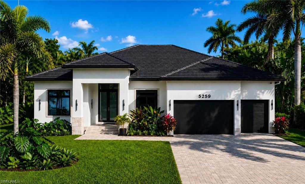 Rendered photo- Contemporary architecture featuring a dark tile roof, white stucco exterior, black windows, and a paver driveway