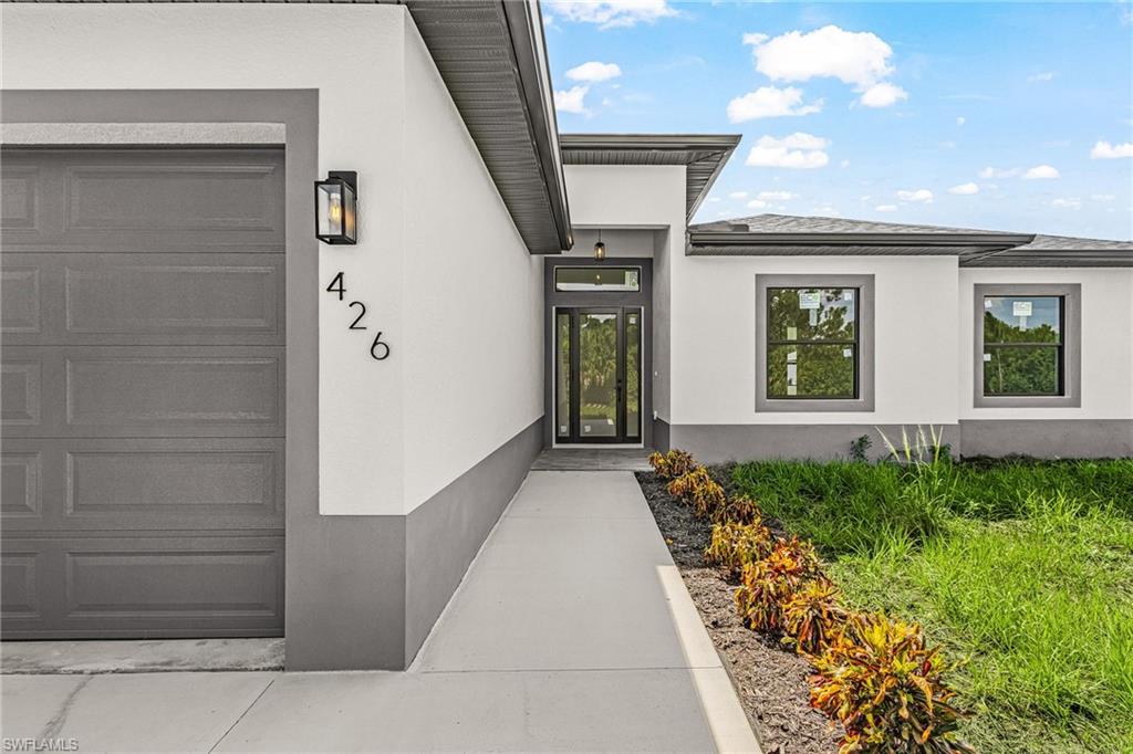 Contemporary exterior with a two-tone facade, attached garage, well-defined entryway, and a covered front porch