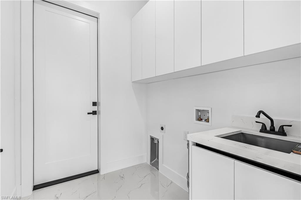 White flat-panel cabinetry, white engineered stone countertop, undermount sink, matte black faucet, and white tile flooring